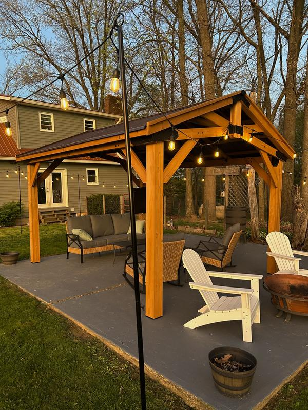 A black metal charcoal grill on a brick patio